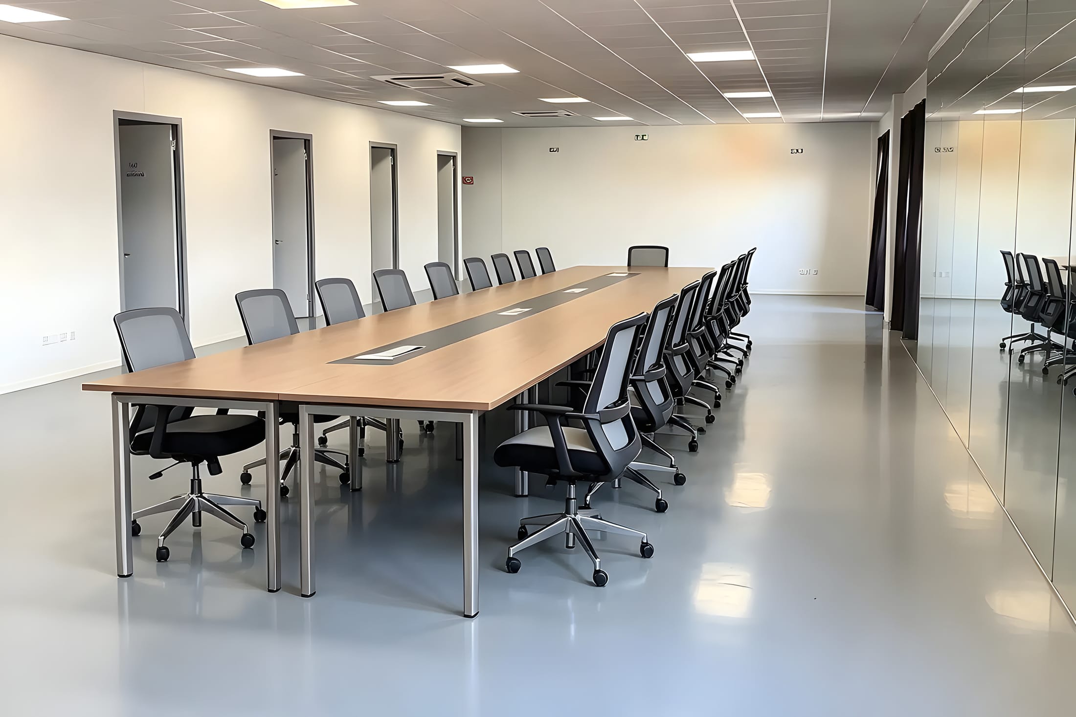 Mise en situation de la salle de réunion en grande table de conseil, devant le mur de miroirs